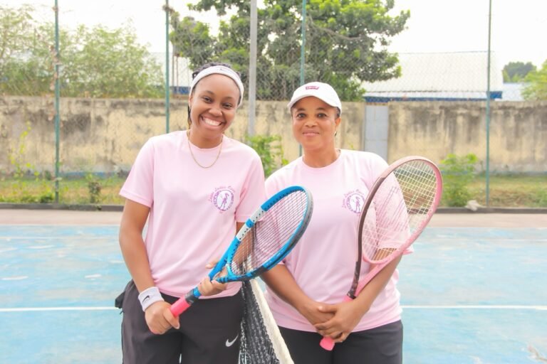 Two smiling players holding their rackets